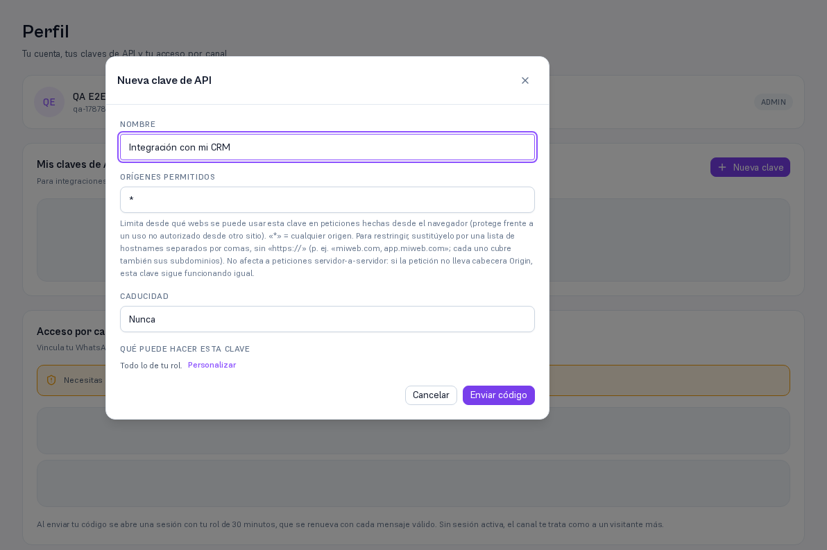 Modal Nueva clave de API con el campo Nombre relleno «Integración con mi CRM», Orígenes permitidos con el valor «*», el desplegable Caducidad en «Nunca» y, bajo «Qué puede hacer esta clave», el resumen «Todo lo de tu rol» con el enlace Personalizar, junto a los botones Cancelar y Enviar código